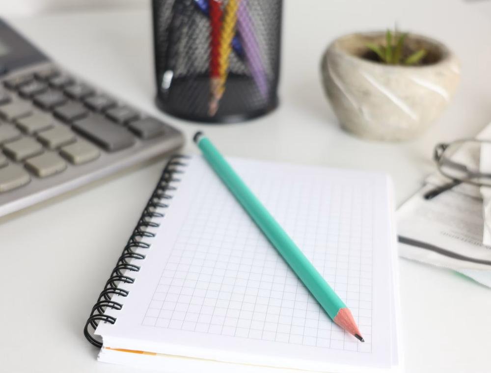 Desk with calculator, notebook and pencil